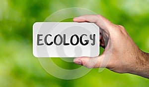 Hand holding placard with word `ECOLOGY`.ECO concept.