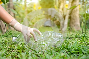 Hand holding plastic bottles waste, Couple picking up trash putting to the black garbage bag at Sunflower Park on Environmental