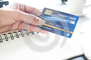 Hand holding plastic credit card. E-payment, technology and online shopping