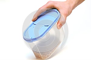 Hand holding plastic food container isolated