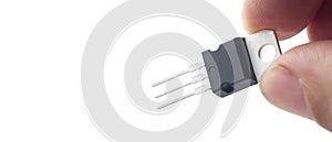 Hand holding a plastic transistor, model 7812