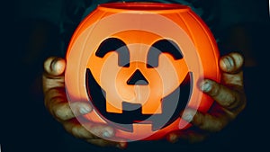 Hand holding a pumpkin of halloween baubles