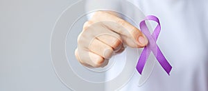 Hand holding purple Ribbon for Pancreatic, Esophageal, Testicular cancer, world Alzheimer, epilepsy, lupus, Sarcoidosis,