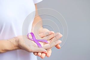 Hand holding purple Ribbon for Pancreatic, Esophageal, Testicular cancer, world Alzheimer, epilepsy, lupus, Sarcoidosis,