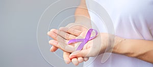 Hand holding purple Ribbon for Pancreatic, Esophageal, Testicular cancer, world Alzheimer, epilepsy, lupus, Sarcoidosis,