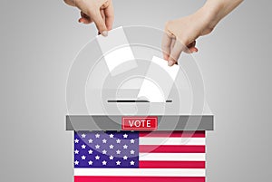Hand holding and putting voting paper in ballot voting box with USA flag symbol.