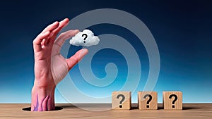 Hand Holding Question Mark Cloud Above Question Blocks On Table