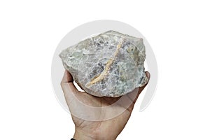 A hand is holding a raw of fluorite rock stone isolated on white background.