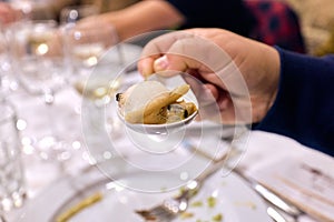 Hand holding a razor shell or clam, ready for eating, no faces are shown