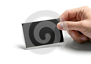 A hand holding a rectangular black object with a textured surface