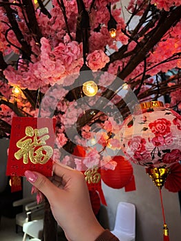 A hand is holding red paper (ampao chinesse tradition)