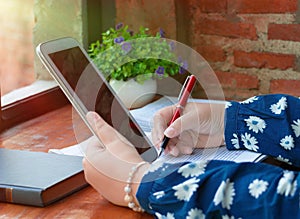 hand holding red pen over blurred paperwork for proofreading