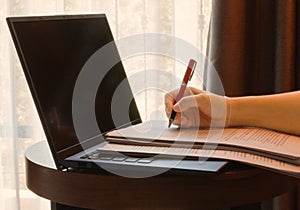 Hand holding red pen over blurred proofreading paper