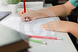 Hand holding red pen over proofreading paper