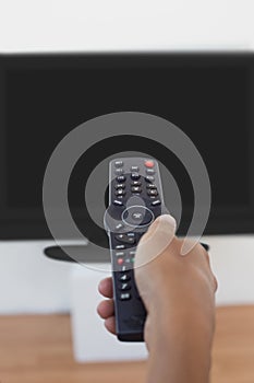 Hand holding remote and changing channel