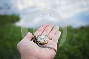 Hand holding retro stopwatch in natural background