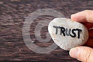 Hand-holding rock with handwritten word 