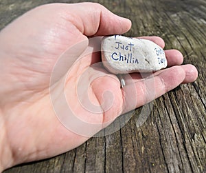 Hand holding a rock with inspirational sentiment