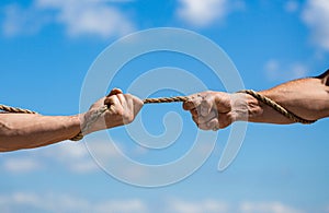 Hand holding a rope, climbing rope, strength and determination. Rescue, help, helping gesture or hands. Conflict, tug of