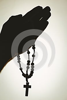 Hand holding rosary beads