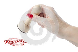 Hand holding a rubber stamp with the word destroy photo