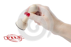 Hand holding a rubber stamp with the word file