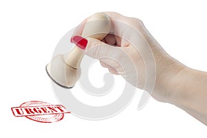 Hand holding a rubber stamp with the word urgent