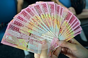 Hand holding rupiah Indonesian money