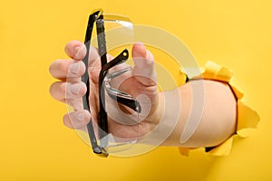 Hand holding safety glasses