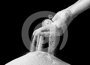 Hand holding sand and clock