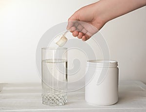 Hand holding scoop of fish collagen. collagen peptides in container or jar. photo