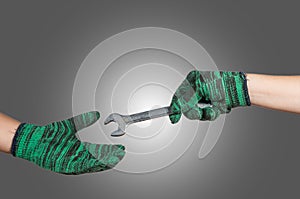 hand holding and sending the wrench on gray background. industrial equipment