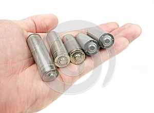 Hand holding set of unlabelled AA batteries