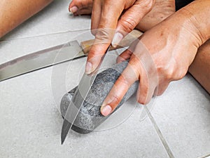 Hand holding sharpen knife and whetstone