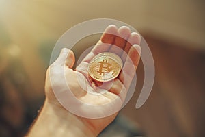 hand holding shiny golden bitcoin, gold money. digital currency, bit coin on people palm, cryptocurrency concept.space for