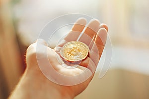 hand holding shiny golden bitcoin, gold money. digital currency, bit coin on people palm, cryptocurrency concept.space for