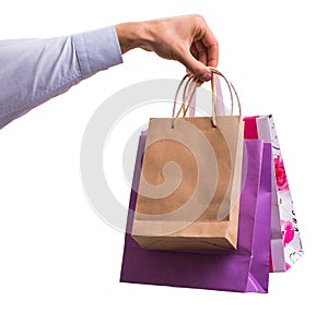 Hand holding shopping bags with christmas shopping on white back