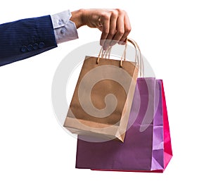 Hand holding shopping bags with christmas shopping on white back