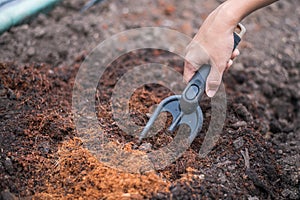 Hand holding shoveling fork for loosening soil