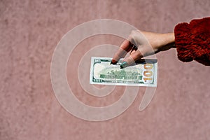 Hand holding showing dollars money and giving or receiving money like tips, salary. 100 USD banknotes, American Dollars currency