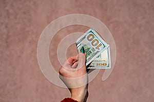 Hand holding showing dollars money and giving or receiving money like tips, salary. 100 USD banknotes, American Dollars currency