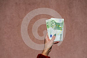Hand holding and showing euro money or giving money. World money concept, 100 EURO banknotes EUR currency isolated. Concept of