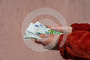 Hand holding and showing euro money or giving money. World money concept, 100 EURO banknotes EUR currency isolated. Concept of