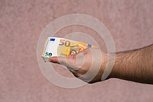 Hand holding showing euro money and giving or receiving money like tips, salary. 50 EURO banknotes EUR currency . Concept