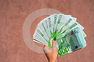 Hand holding and showing a fan of euro money or giving money. World money concept, 100 EURO banknotes EUR currency isolated.