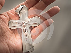 Hand holding a silver cross.Christianity