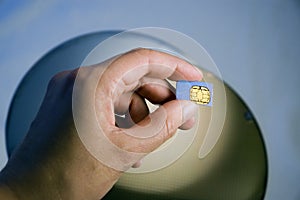 Hand Holding SIM Module Over Silicon Wafers