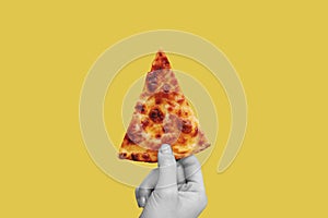 Hand holding slice of Classic cheese pizza, on yellow background
