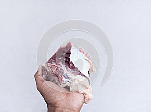 Hand holding sliced fresh raw beef isolated on white background. The feast of Qurban Ied al adha mubarak.