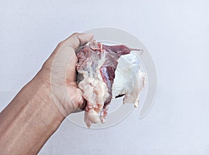 Hand holding sliced fresh raw beef isolated on white background. The feast of Qurban Ied al adha mubarak.